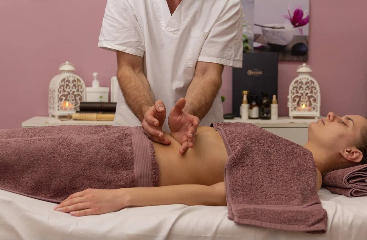 A gentle abdominal massage, the client covered with towels