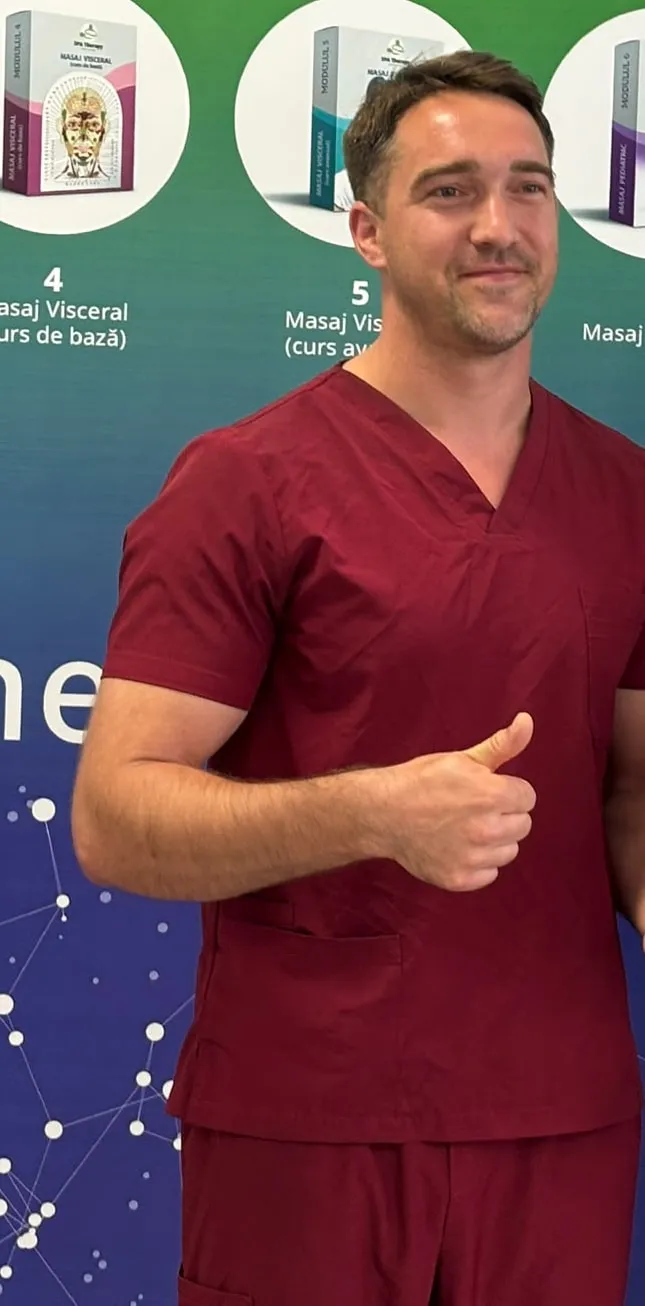 Constantin in burgundy work scrubs at a massage training centre