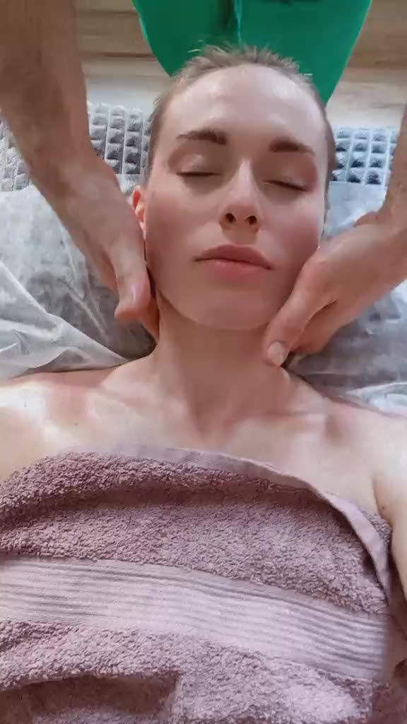 A facial massage seen from above, the client resting with eyes closed
