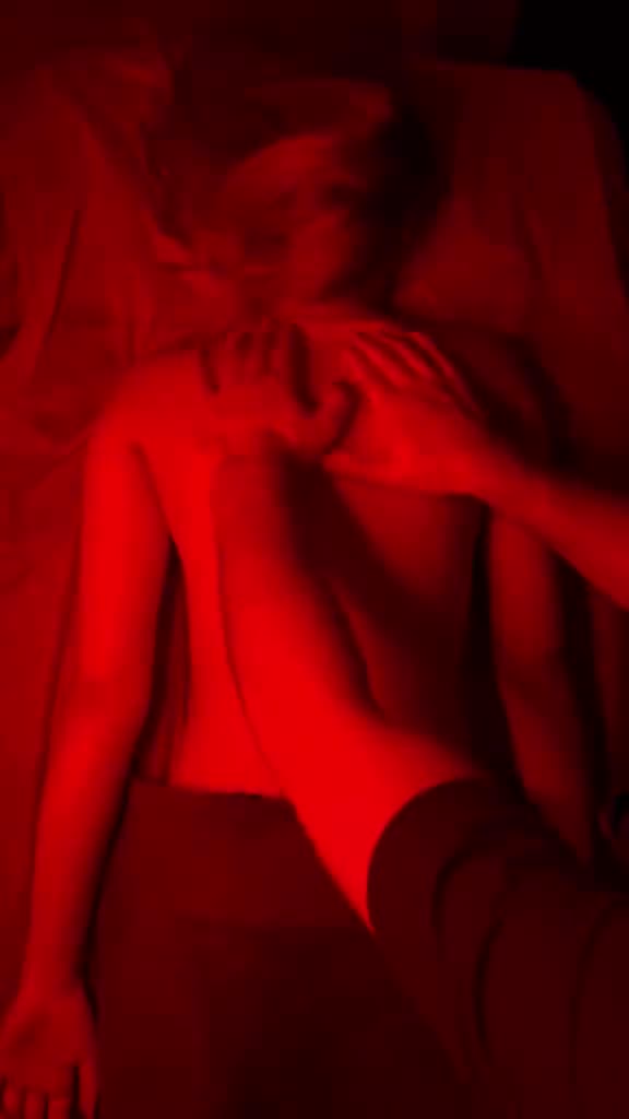 A shoulder and upper back massage under warm red light