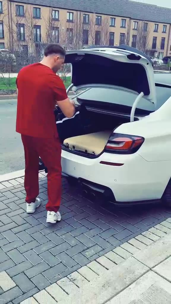 Constantin unloading his massage table and bag from the car before a home visit